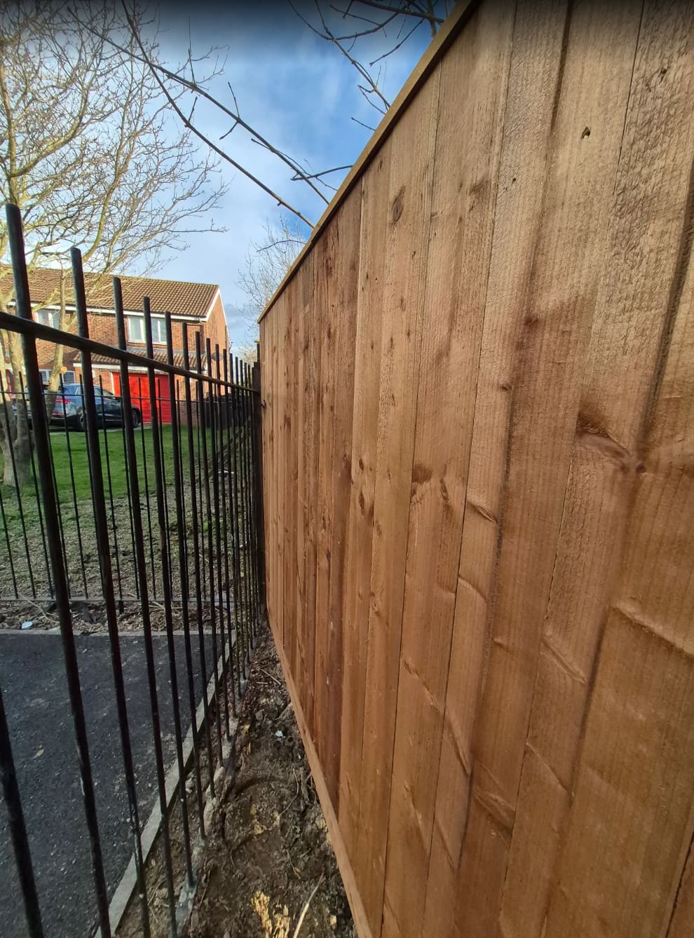 The new fence meeting the existing metal railings