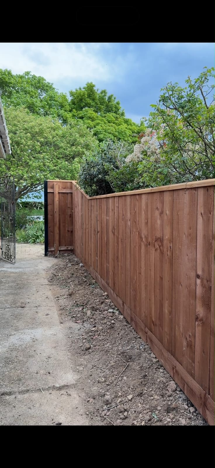 The fence line running down to an ornamental iron gate
